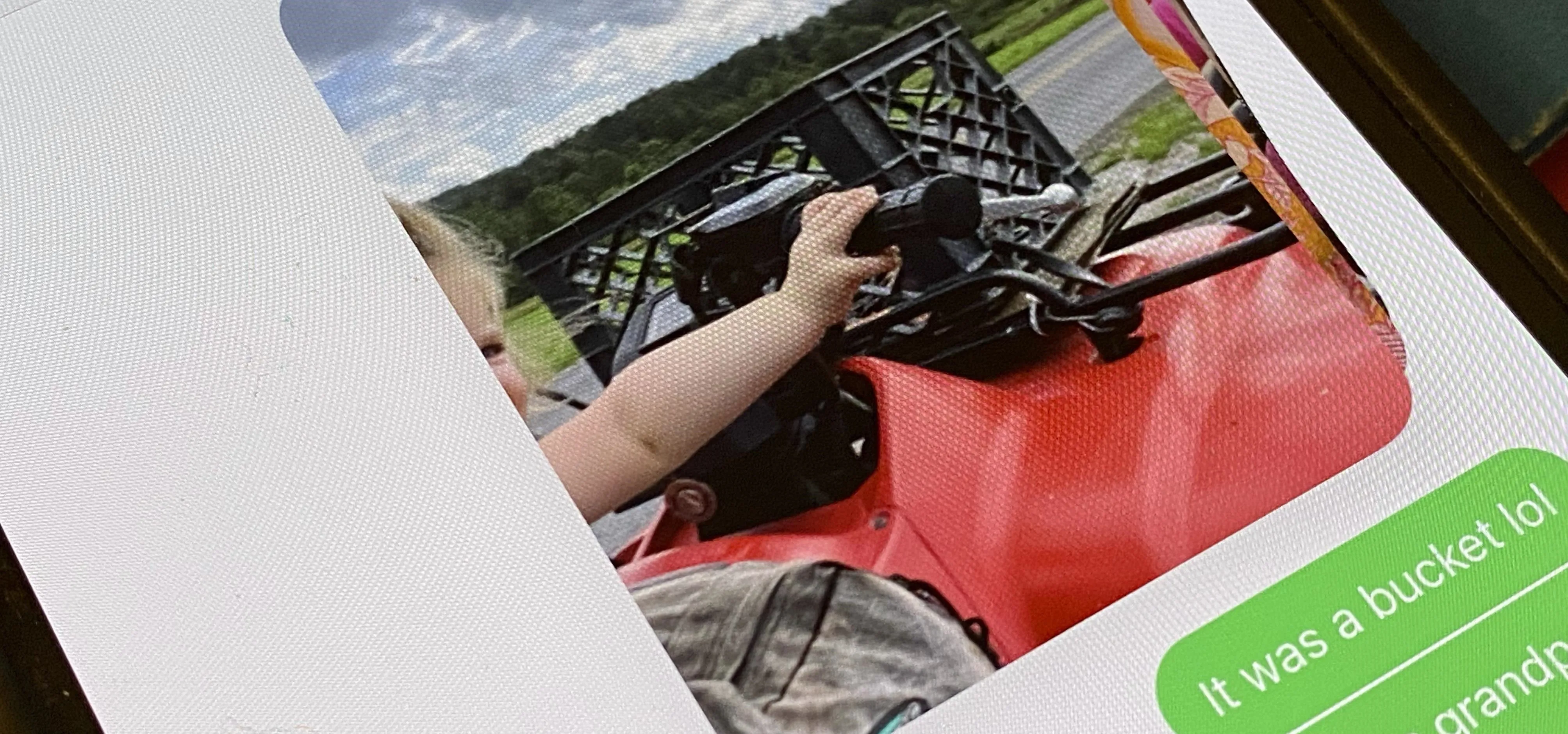Child's hand on a red ATV while outdoors.