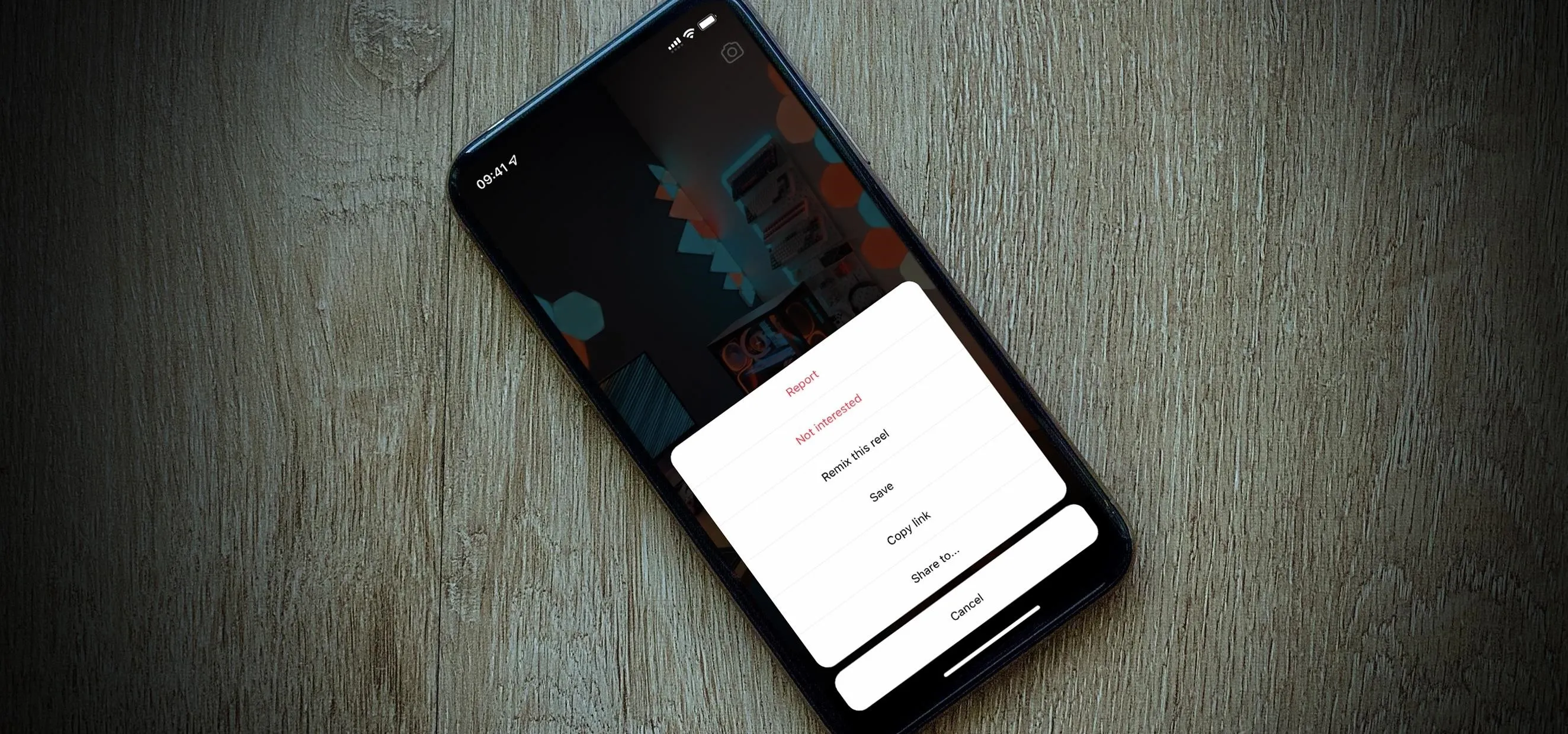 Mobile phone displaying a menu on a wooden surface.