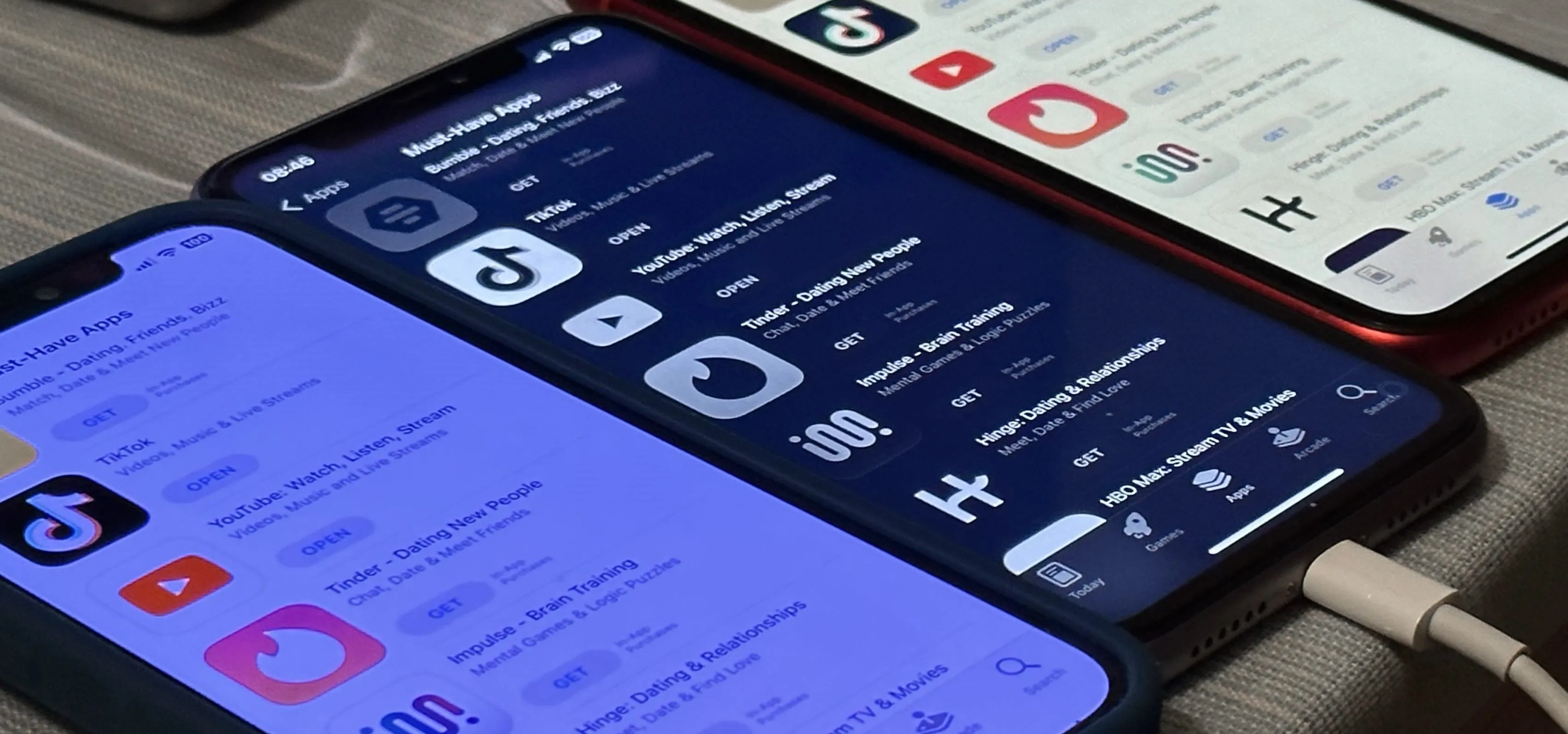 Three smartphones displaying various social media and dating apps on their screens.