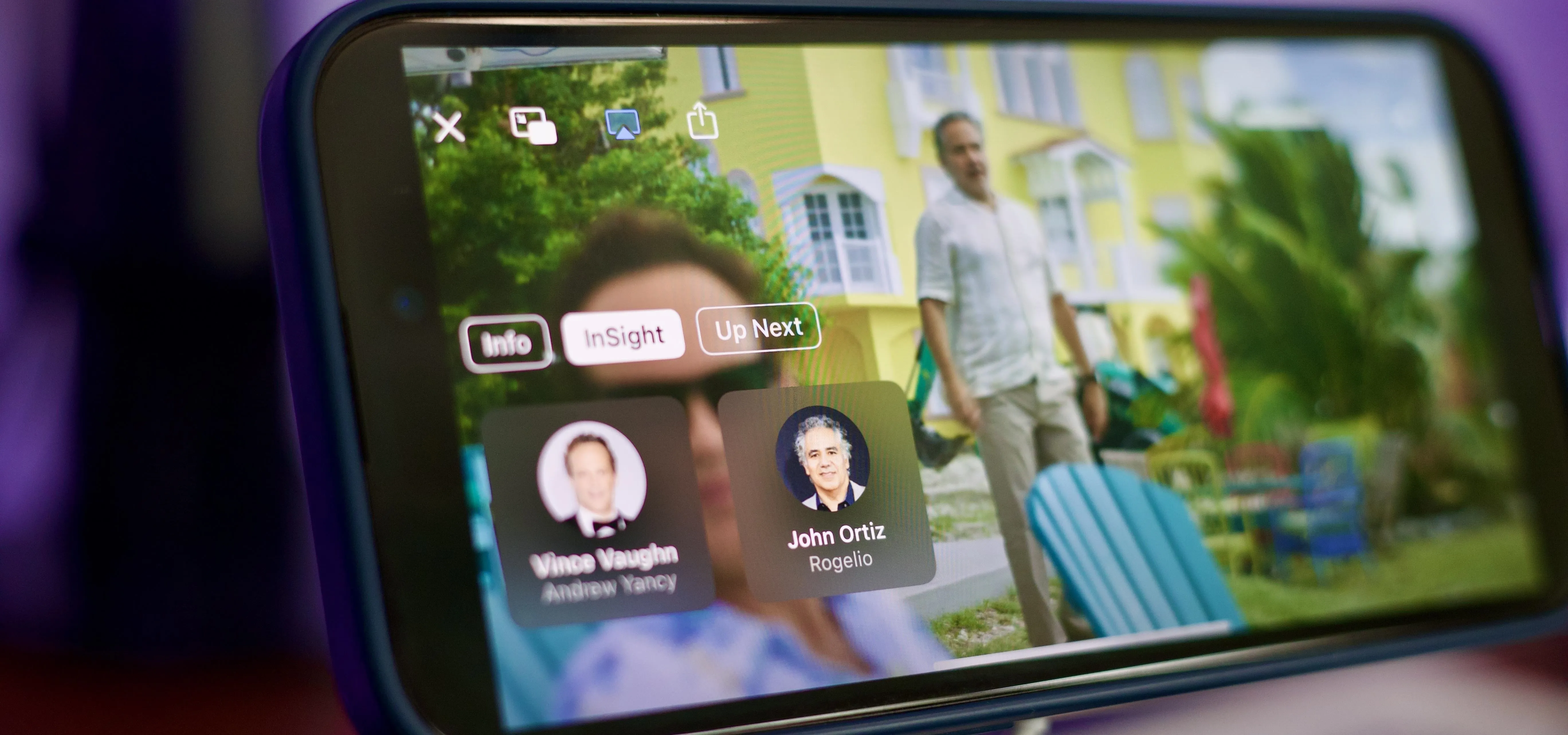 Mobile phone displaying a video call interface with two contact names and a colorful outdoor background.